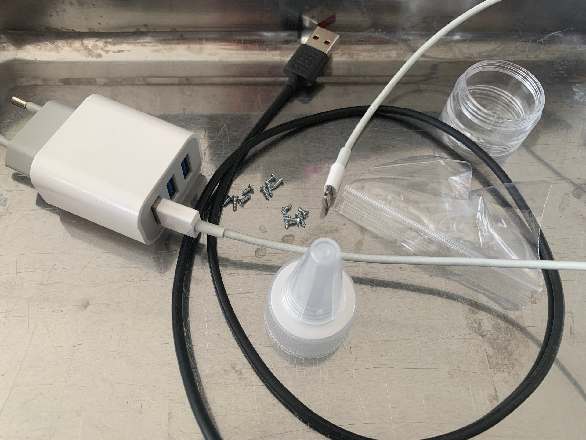 Transparent and reflective objects: charger, cables, screws, plastic cap and jar